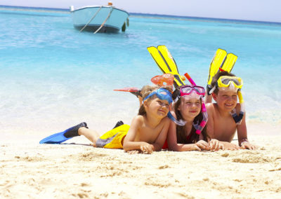 Bambini sorridenti con pinne e maschere in vacanza